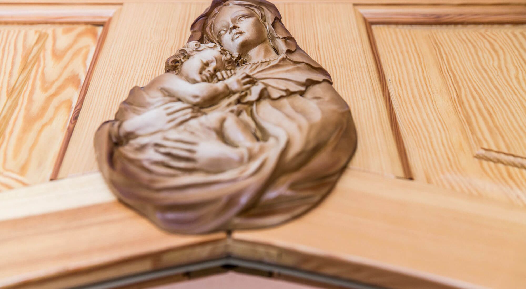 Heilige Maria mit Jesuskind an einer Holztür