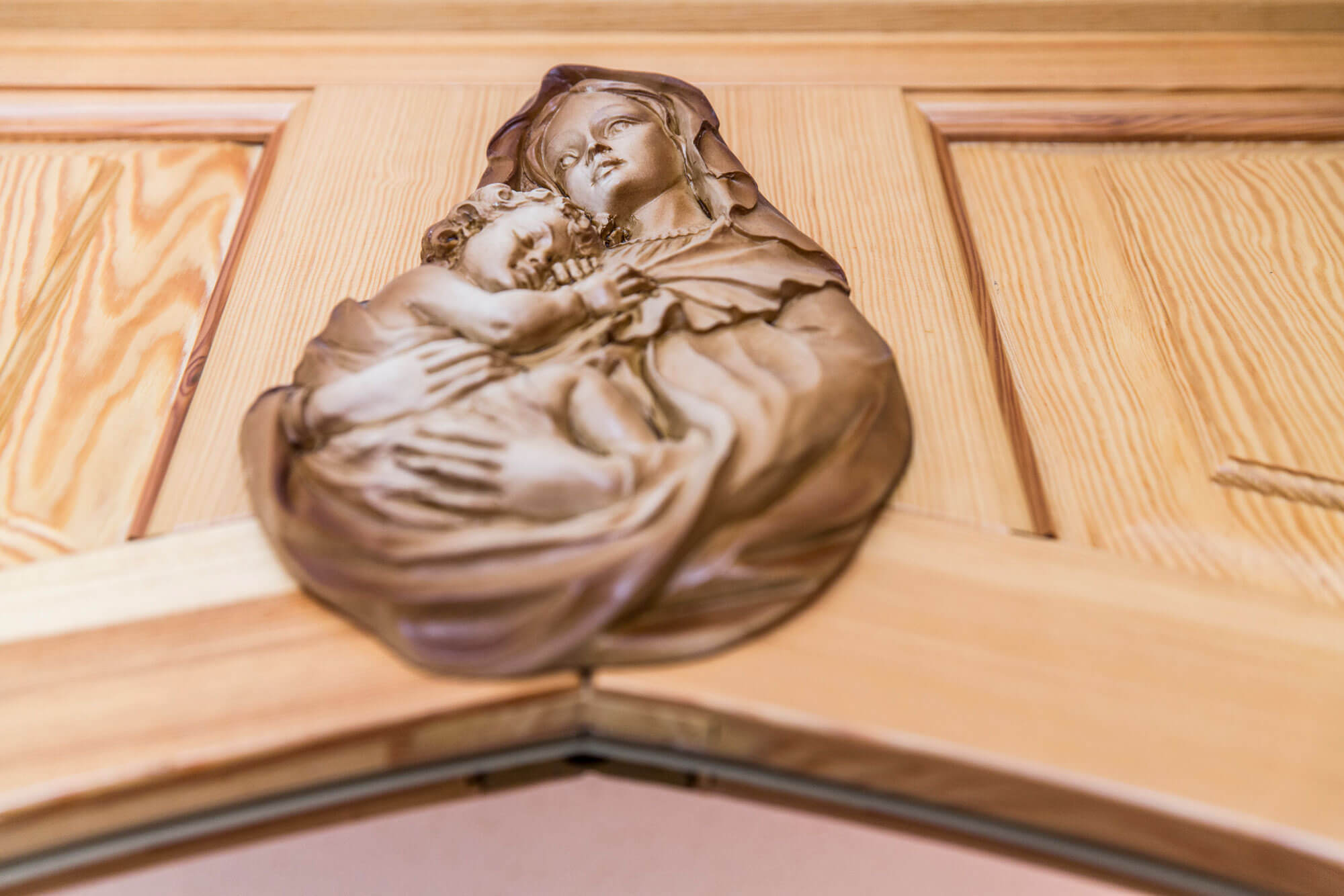 Heilige Maria mit Jesuskind an einer Holztür